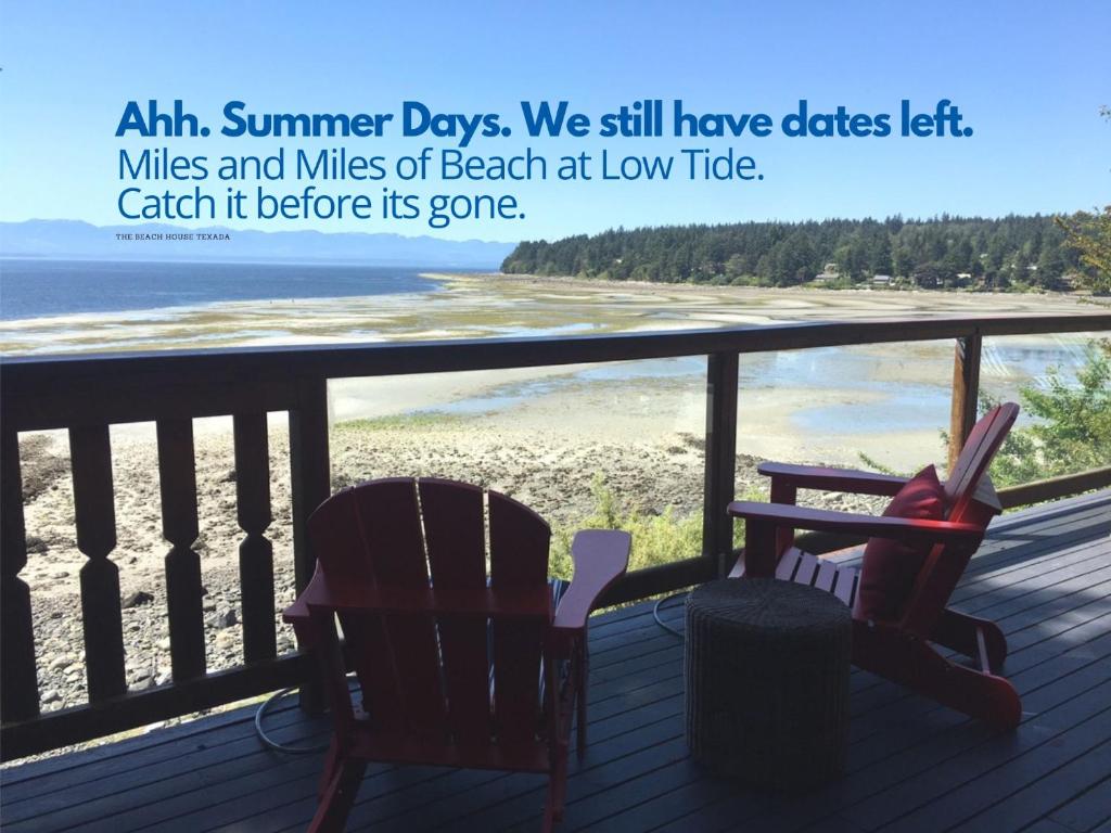 Gillies BayThe Beach House Texada - Waterfront Cabin的阳台配有两把椅子,享有海滩美景