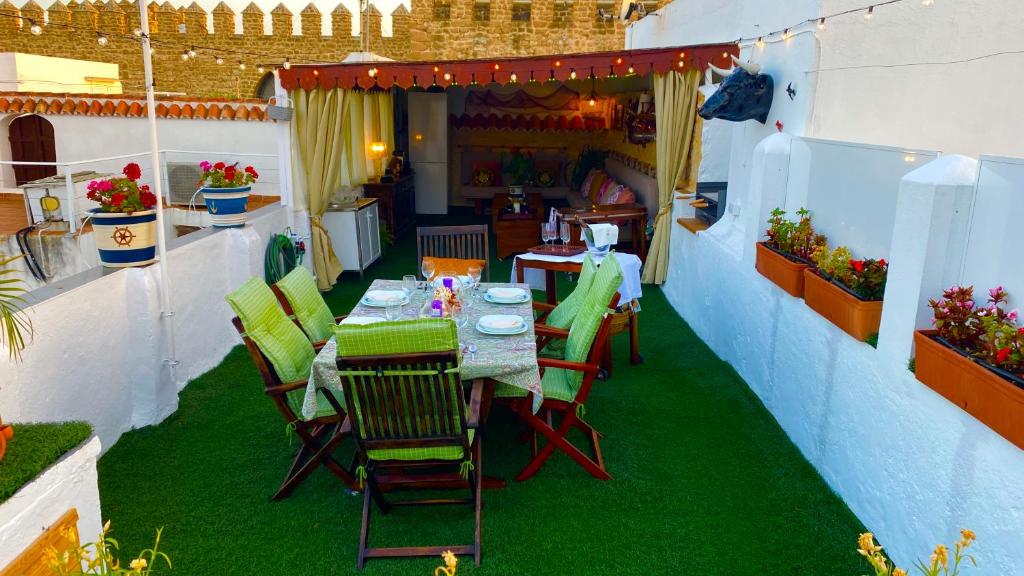 罗塔Apartamento con Terraza,a 100m playa Costilla y Frente al Castillo的绿草庭院里的桌椅