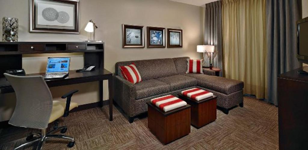 佛罗伦萨Staybridge Suites - Florence Center, an IHG Hotel的酒店客房设有沙发、书桌和笔记本电脑