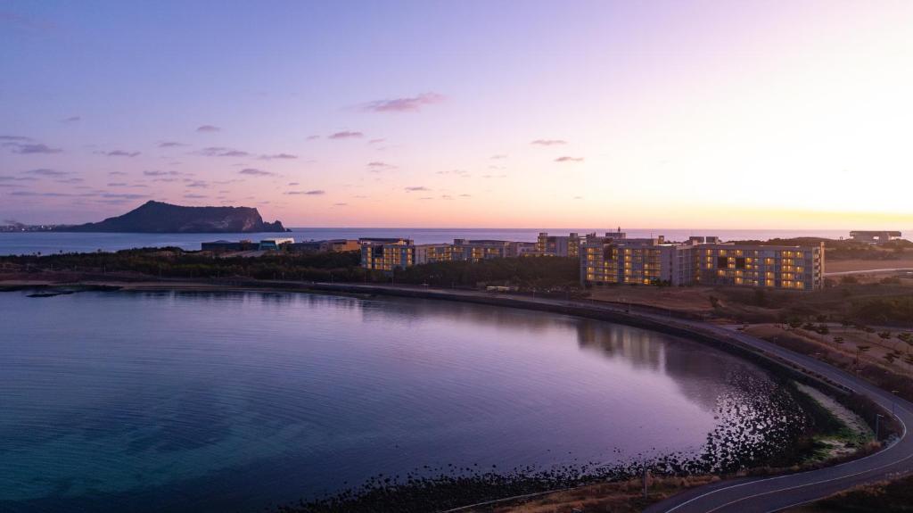 西归浦市Phoenix Island的一大片水体,有建筑背景