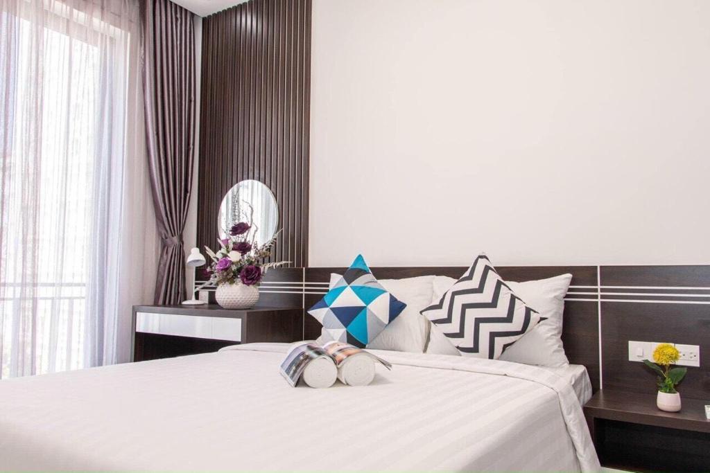 岘港Carol Homestay & Apartment 1的一间卧室配有一张带白色床单的大床