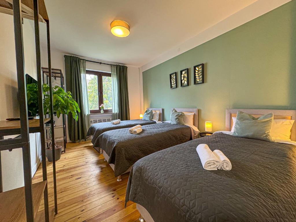 不莱梅ImmoStay #7 -Helle Wohnung mit großem Garten -4 Zimmer, WiFi & Free Parking的一间卧室设有两张床和窗户。