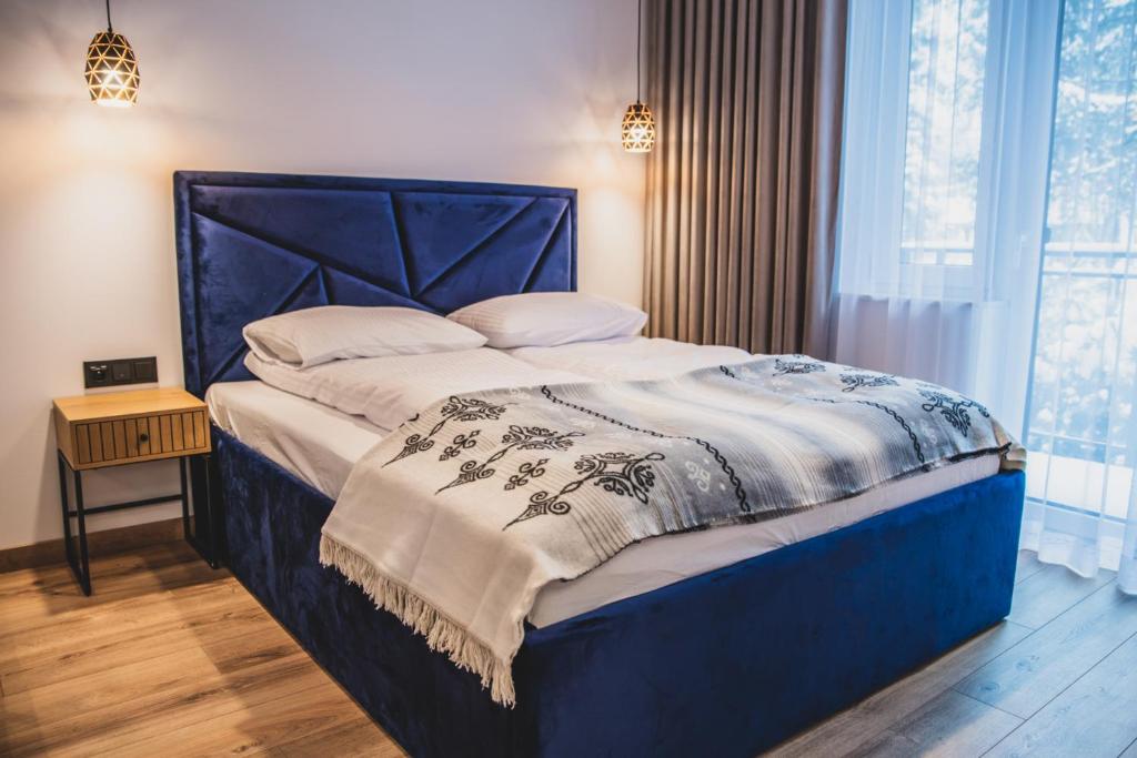 扎科帕内Apartamenty Górski Kryształ的一张带蓝色床头板的睡床