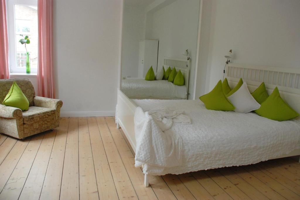 汉诺威斯威特克莱门汀住宿加早餐旅馆的一间卧室配有一张带绿色枕头的床和一把椅子