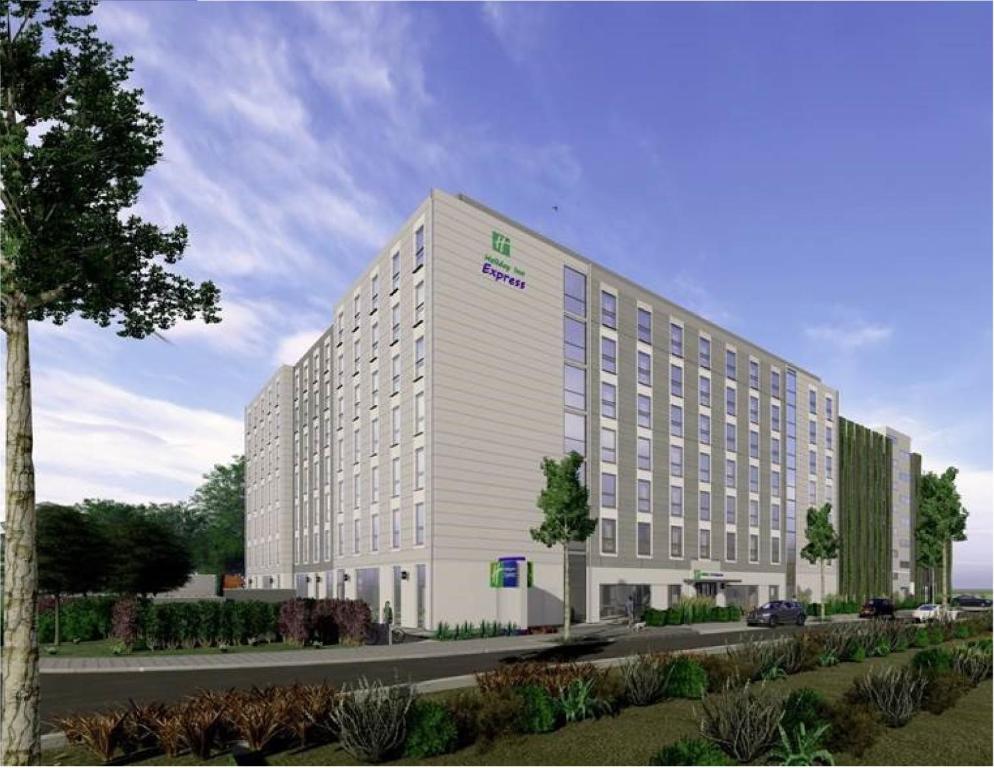 杜塞尔多夫Holiday Inn Express - Düsseldorf Airport的街道旁的白色大建筑