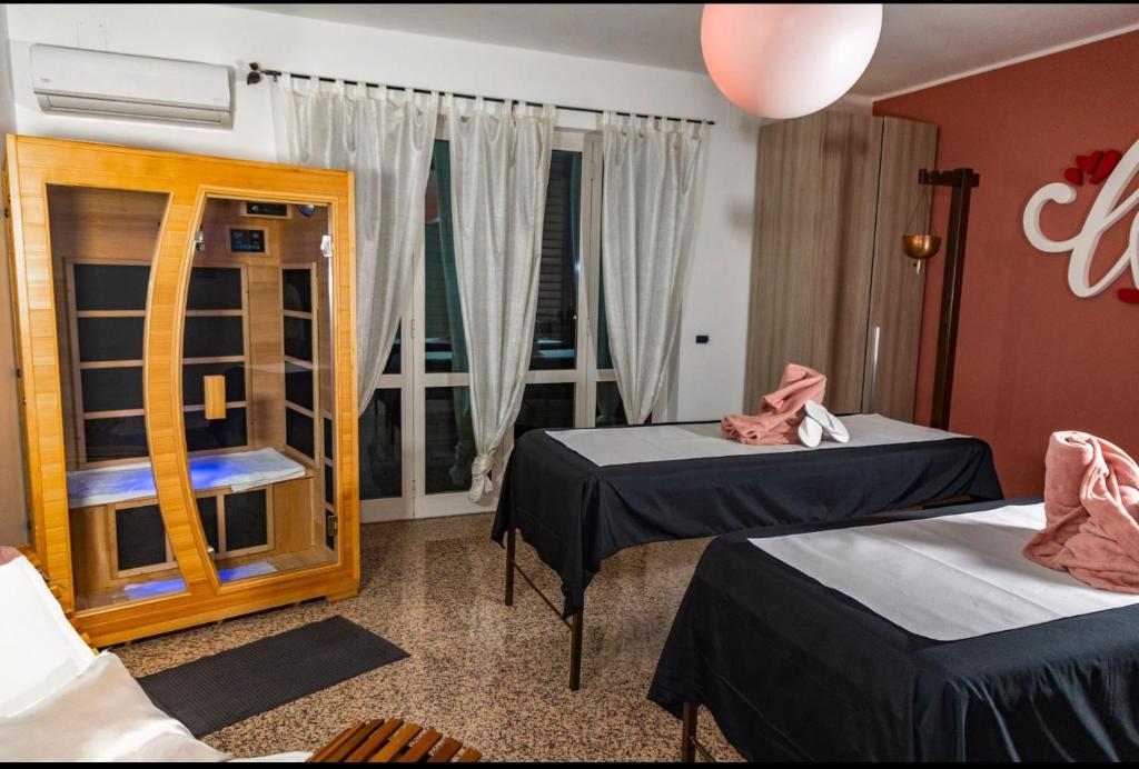 Villa BadessaAndale SuiteSpa的客房设有两张床和窗户。