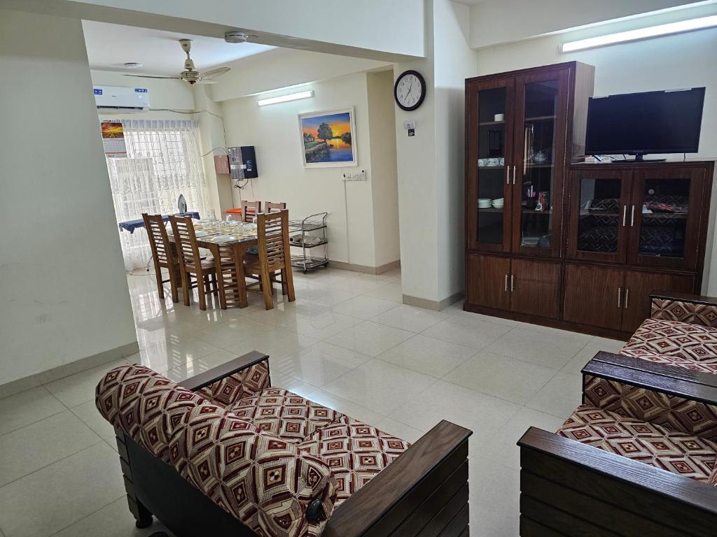 达卡Sweet Rest Dhaka的一间带两张沙发的客厅和一间用餐室