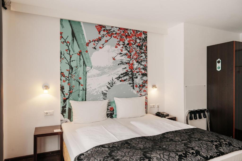 慕尼黑慕尼黑城中心赫尔维蒂亚酒店的卧室配有一张床,墙上挂有绘画作品