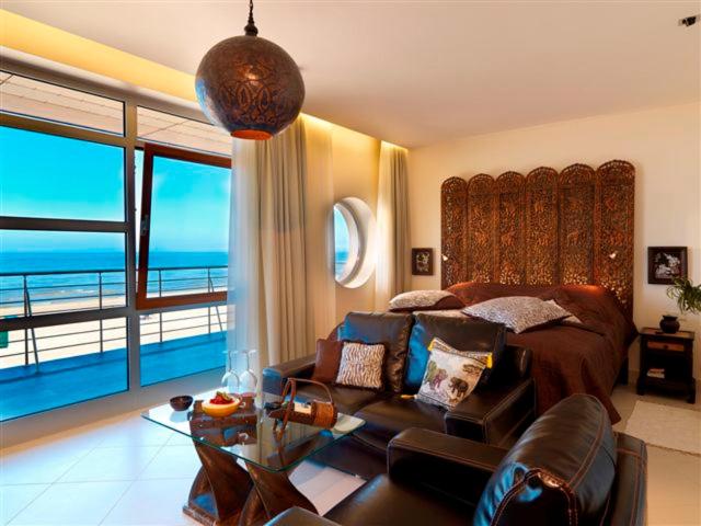 尤尔马拉Boutique Hotel Light House Jurmala的卧室设有一张沙发和一张享有海景的床。