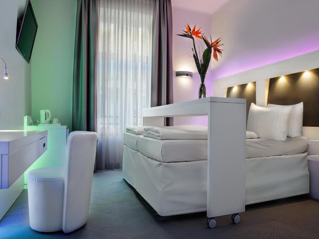 美因河畔法兰克福城中大酒店的卧室配有白色的床和白色沙发