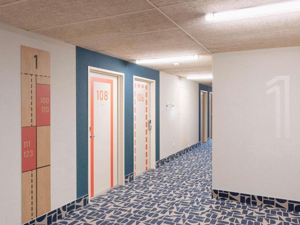 蒙德马桑Ibis Budget Mont De Marsan的办公室走廊,带门和瓷砖地板