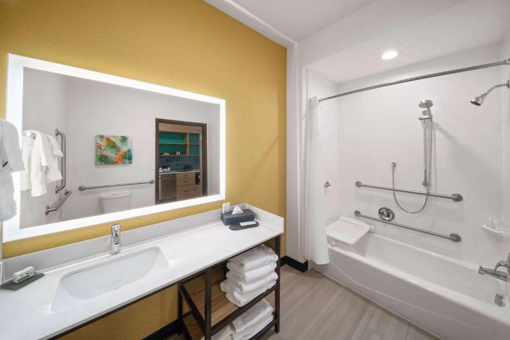 埃尔帕索La Quinta Inn & Suites by Wyndham El Paso East Loop-375的一间带大镜子、浴缸和水槽的浴室