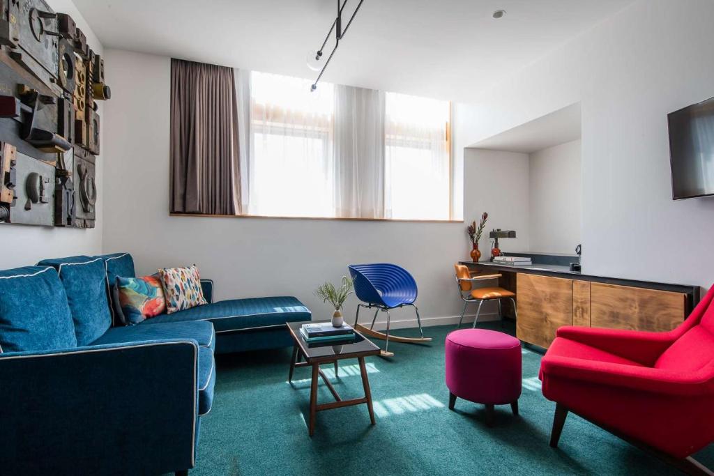 悉尼The Old Clare Hotel, Independent Collection by EVT的客厅配有蓝色的沙发和椅子