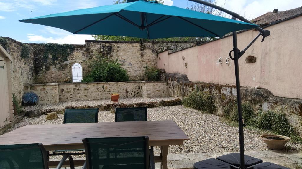La Tour-BlancheBarn cottage的庭院里一张带蓝色遮阳伞的桌子