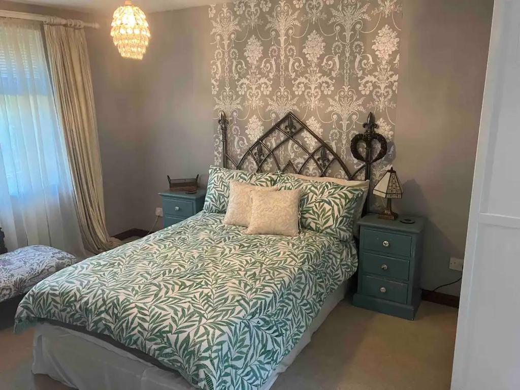 BovingdonCosy Barn Conversion Bedroom & En Suite的一间卧室配有一张带蓝色和白色棉被的床