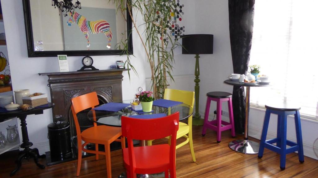 伯恩茅斯竹酒店的用餐室配有五颜六色的椅子和桌子