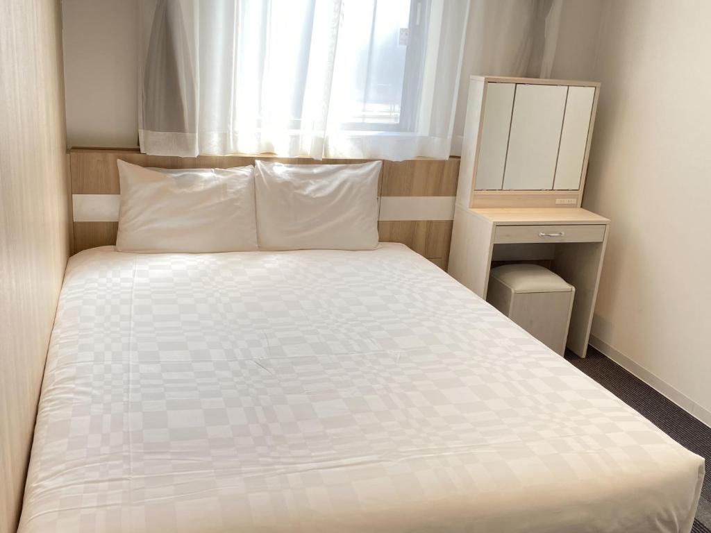 小松市Henn na Hotel Komatsu Ekimae的卧室配有白色的床和窗户。