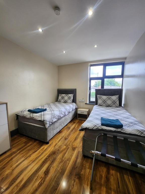 曼彻斯特133 A Park Road的铺有木地板的客房内的两张床