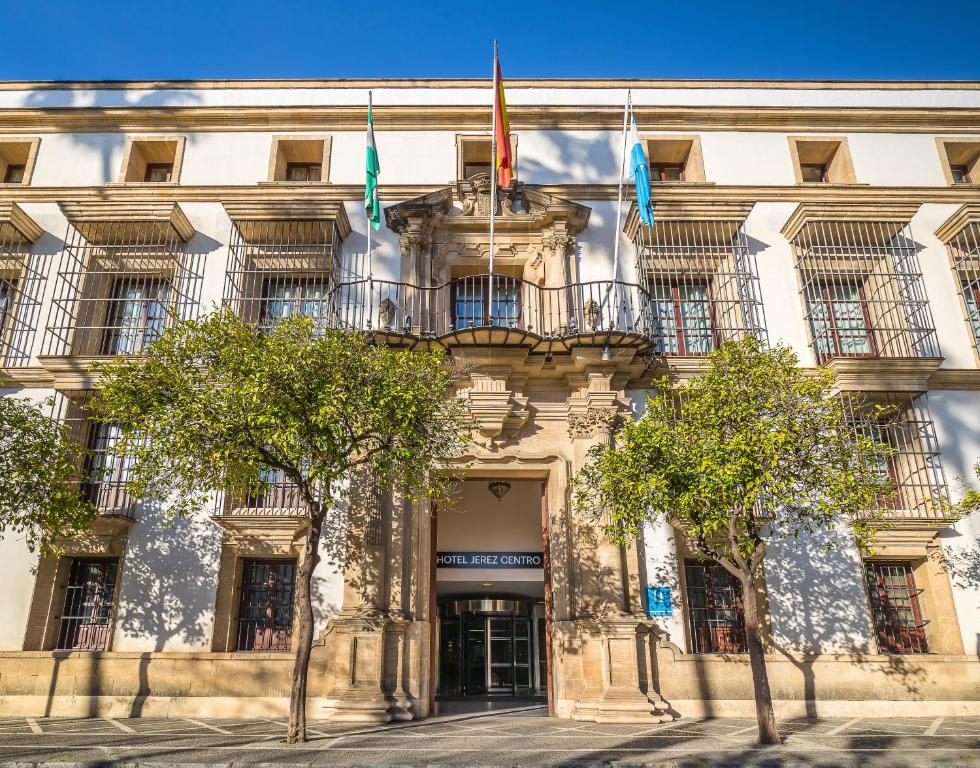 赫雷斯-德拉弗龙特拉Hotel Jerez Centro的前面有三面旗帜的建筑