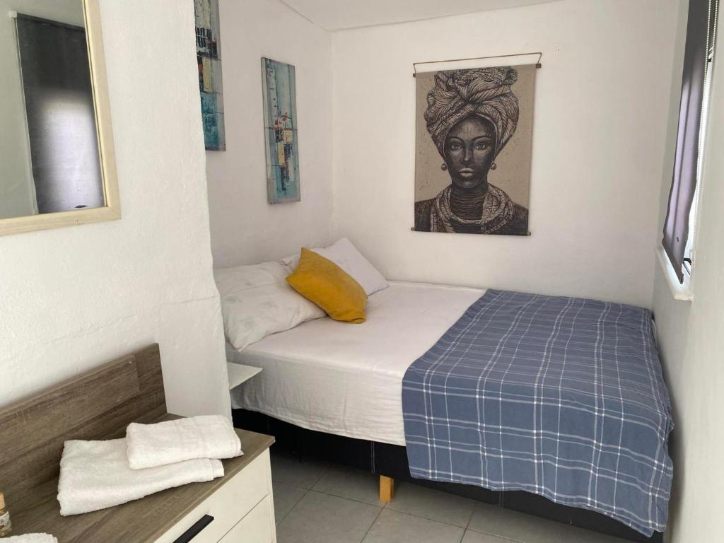 GoníaiPopi's Apartment的小卧室配有一张床和一张女人的肖像