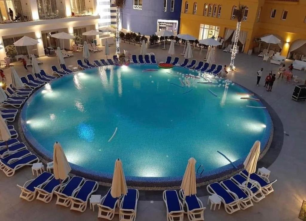 阿莱曼premium sea porto marina suite的享有带躺椅的大型游泳池的顶部景致和池景
