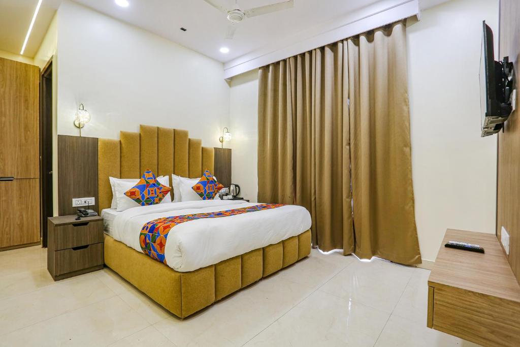 新德里FabHotel Vishesh Villas的一间卧室,卧室内配有一张大床