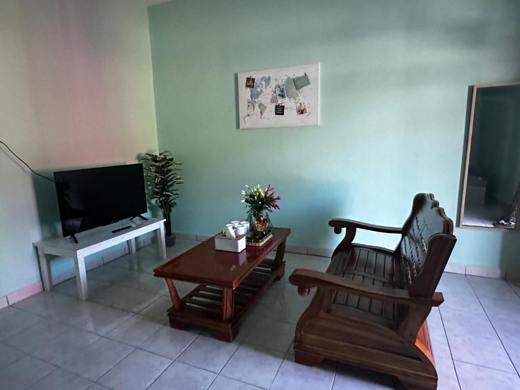 SipitangSipitang Hometown B&B的客厅配有椅子、桌子和电视