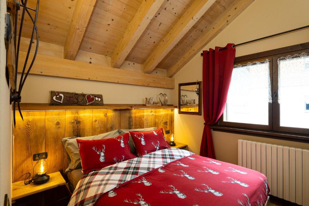 利维尼奥Chalet Da Florin的一间卧室设有红色的床和木墙