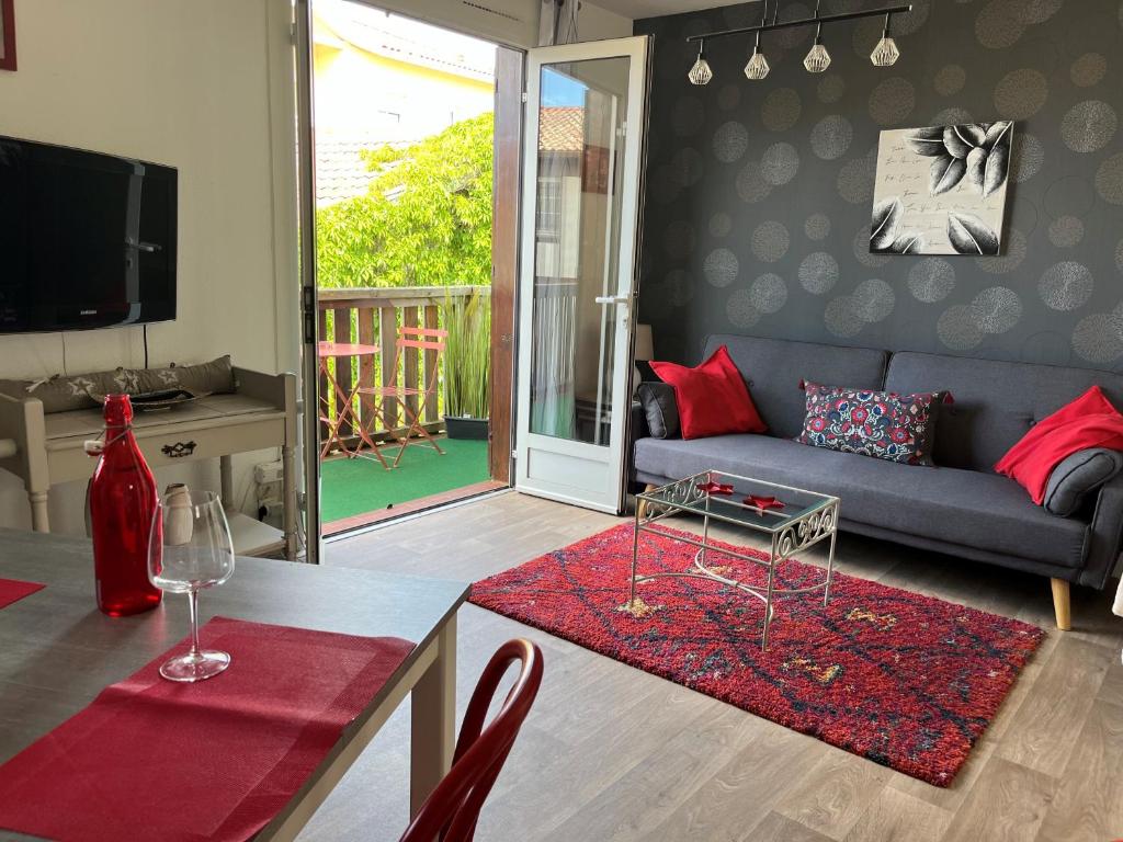 布科·莱斯白老城Appartement Résidence Saint Jours - Centre ville的客厅配有蓝色沙发和红色枕头