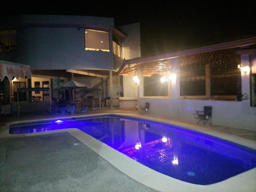 La GaritaVilla Garita Inn的游泳池晚上有紫色灯光