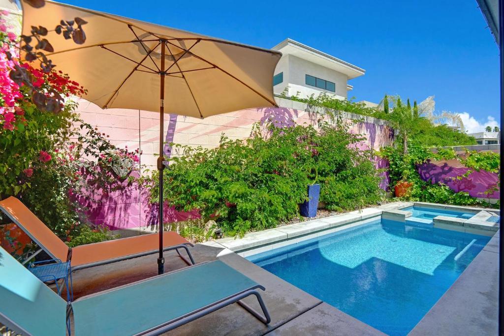 棕榈泉The Luxe Vibe的游泳池旁的椅子和遮阳伞