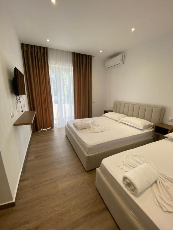 都拉斯Vila Beqja的酒店客房设有两张床和电视。