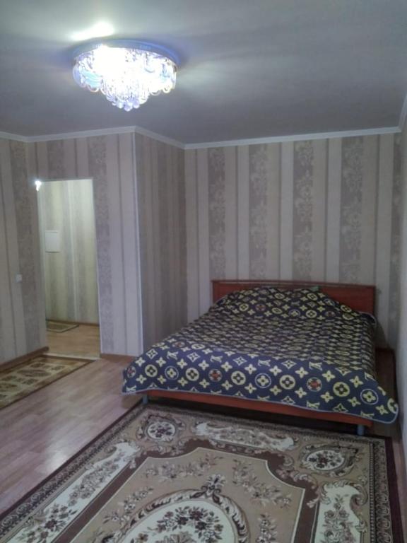 阿克托比1 комн. квартира на Есет батыра的一间卧室配有一张床和一个吊灯
