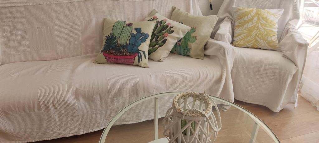 罗达德瓦拉ENCANTADOR apartamento frente a la playa de Bara的配有枕头和玻璃桌的白色沙发
