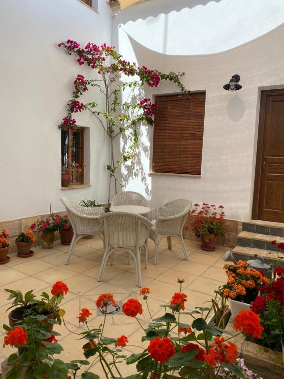 蒙蒂利亚Casa Cordón的庭院配有桌椅和鲜花