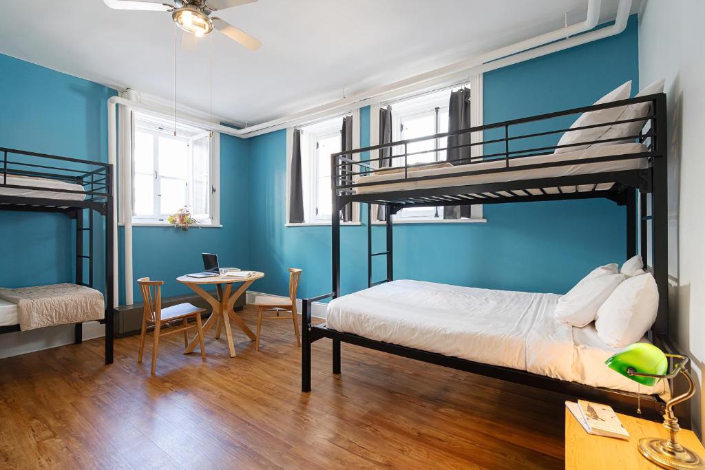 魁北克市Auberge Internationale de Quebec - HI CANADA的一间卧室设有两张双层床和一张桌子