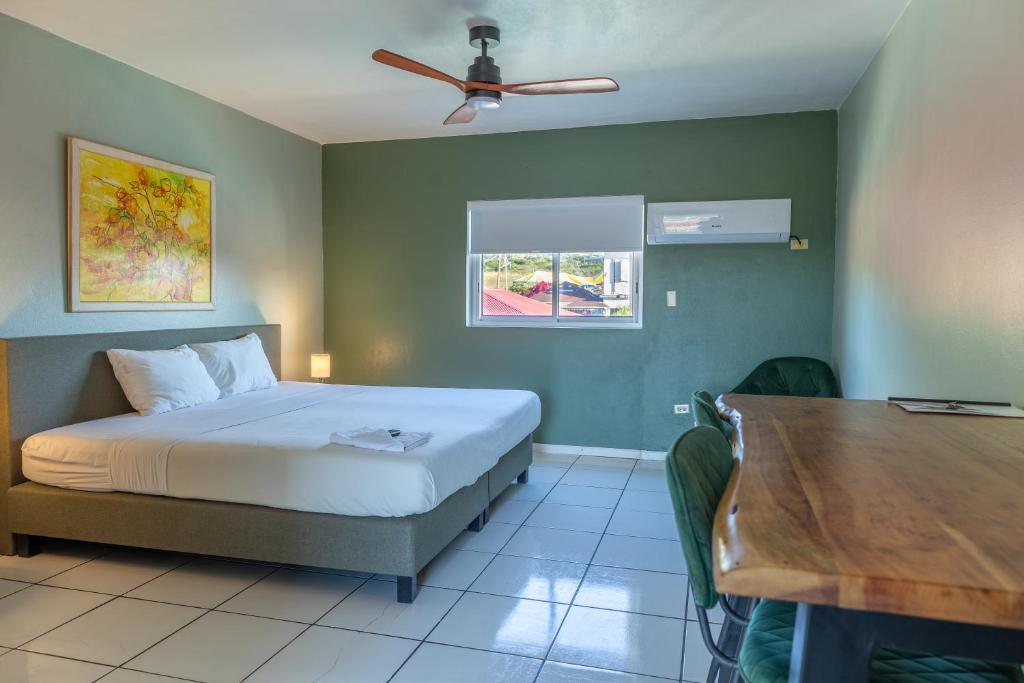 奥拉涅斯塔德Talk of the Town Inn & Suites - St Eustatius的一间卧室配有一张床和一张木桌
