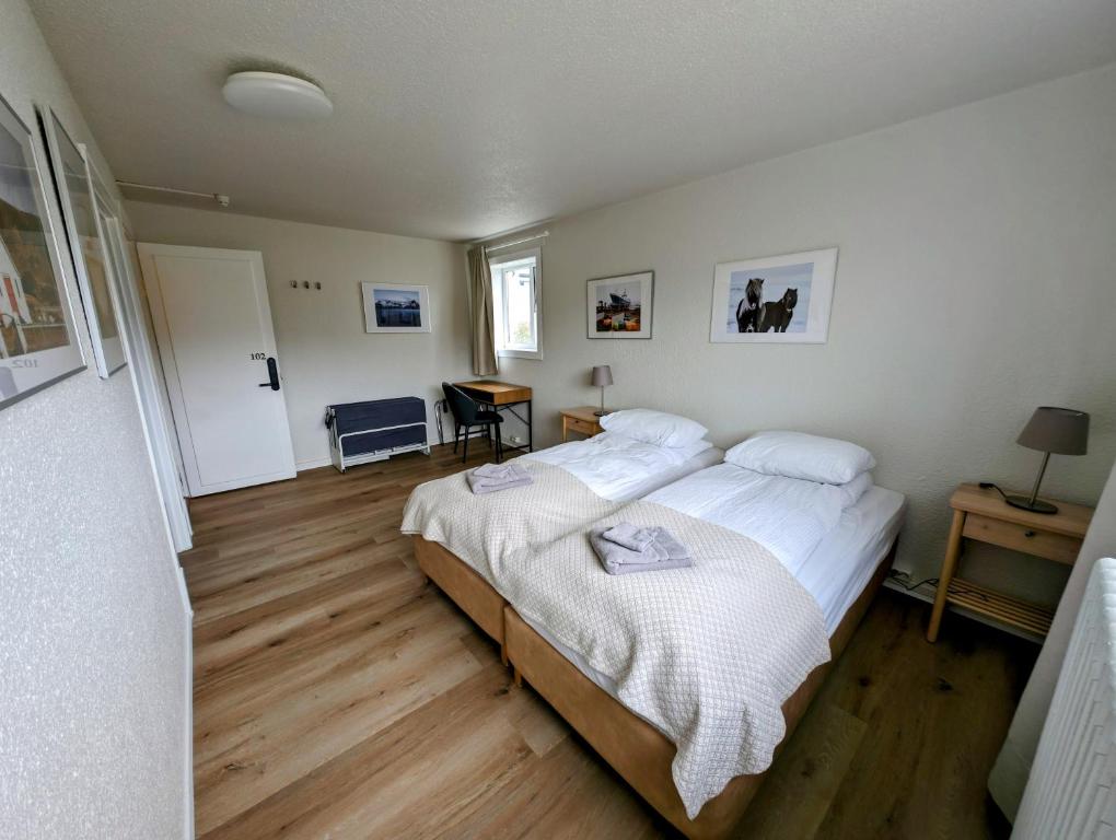 斯蒂克松鲁姆The Stykkishólmur Inn的一间卧室配有一张带白色床单的大床