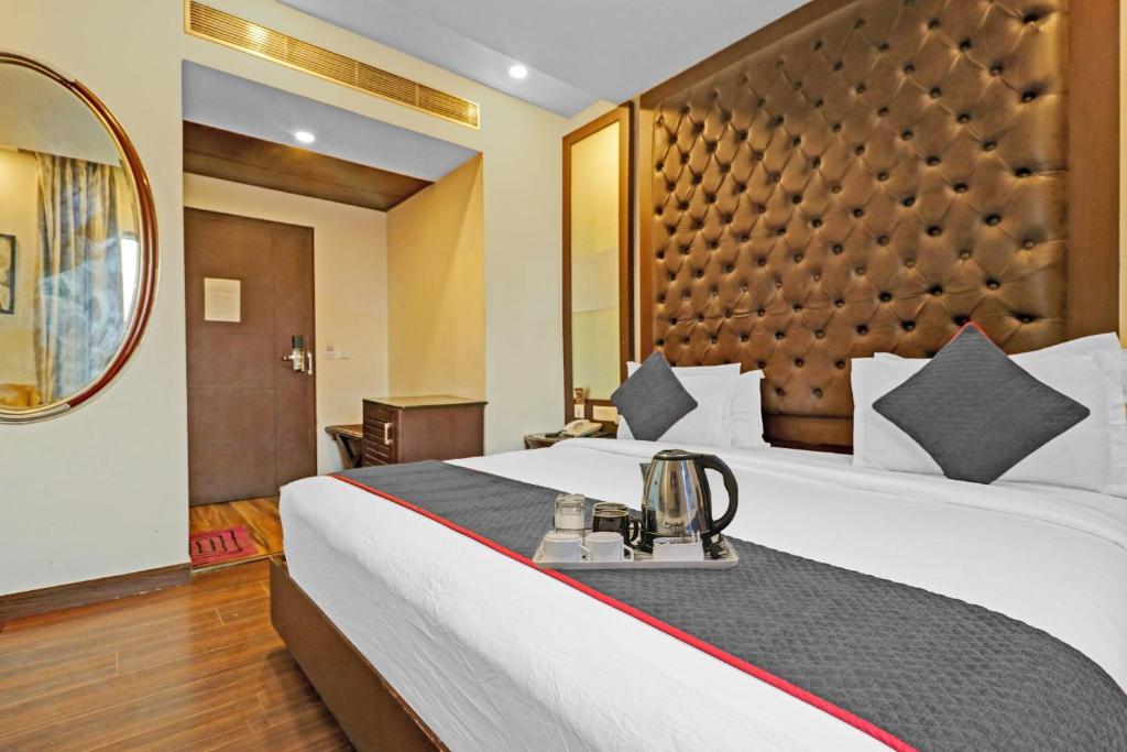 新德里Grand Empire Suites By Delhi Airport的配有一张大床和镜子的酒店客房
