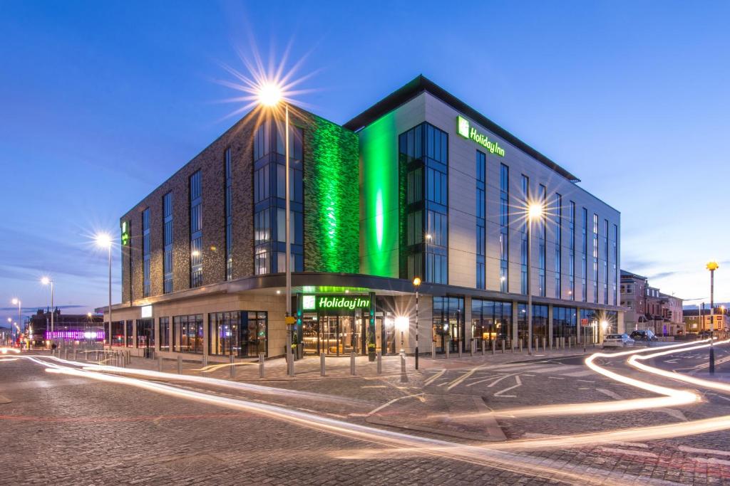 布莱克浦Holiday Inn Blackpool, an IHG Hotel的建筑的一侧有绿灯