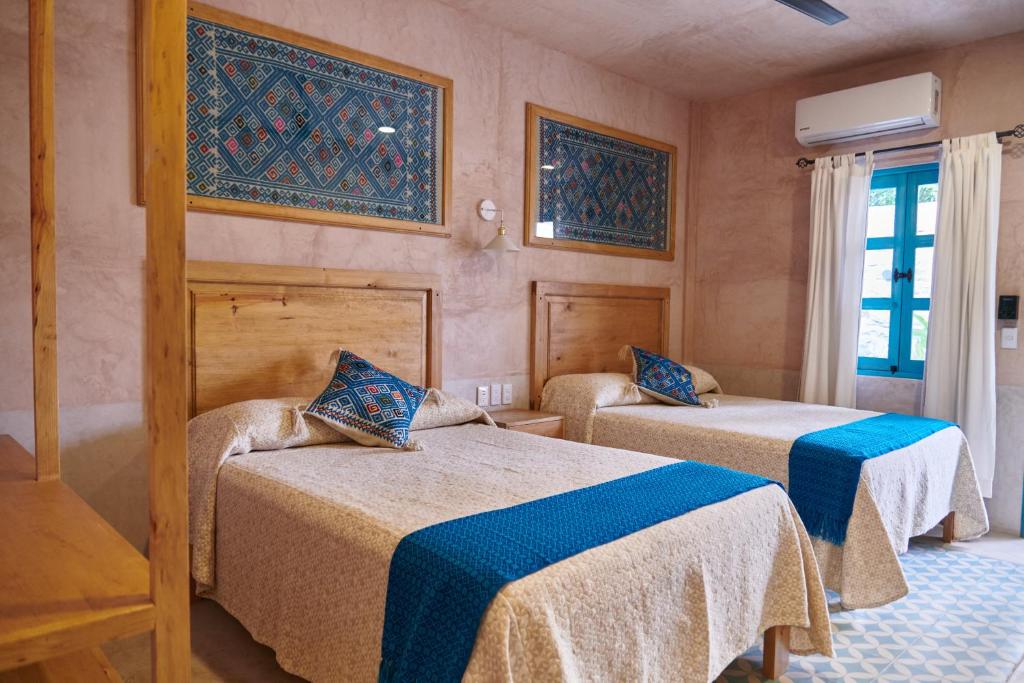 恰帕德科尔索Hotel Mansión Chiapa的客房设有两张床和窗户。