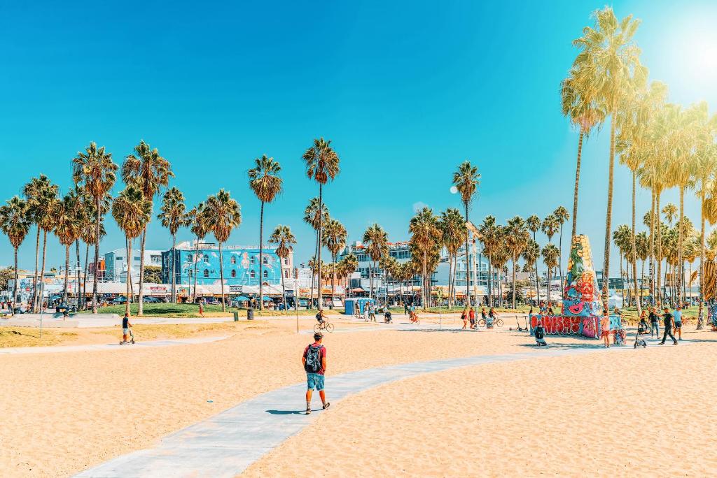 洛杉矶Samesun Venice Beach Hotel & Hostel的站在棕榈树海滩上的人