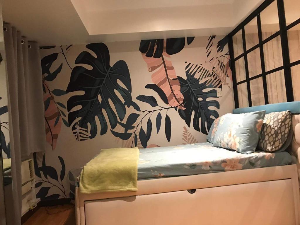 马尼拉Azure Urban Resort Condo Parañaque near NAIA Airport Free Highspeed WIFI and Netflix的一间卧室,墙上挂着植物壁画