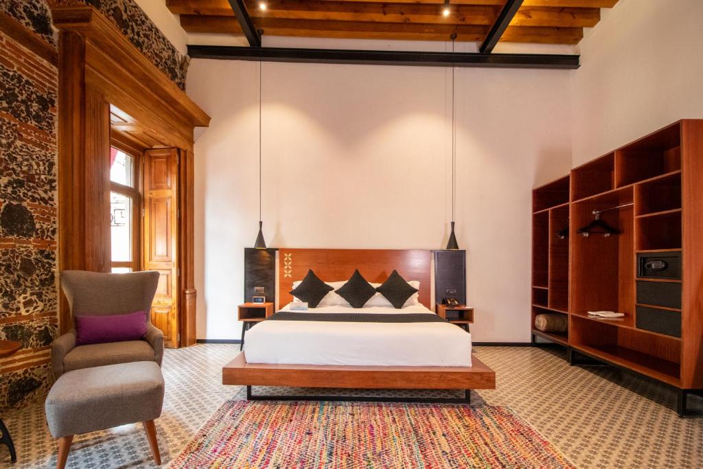 墨西哥城Casa de la Luz Hotel Boutique的一间卧室配有一张床和一把椅子