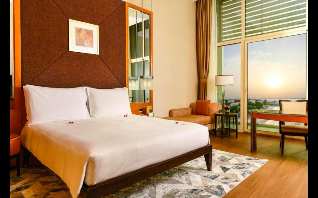 阿布扎比Al Raha Beach Hotel - Deluxe Gulf Room SGL - UAE的一间带大床的卧室和一间客厅
