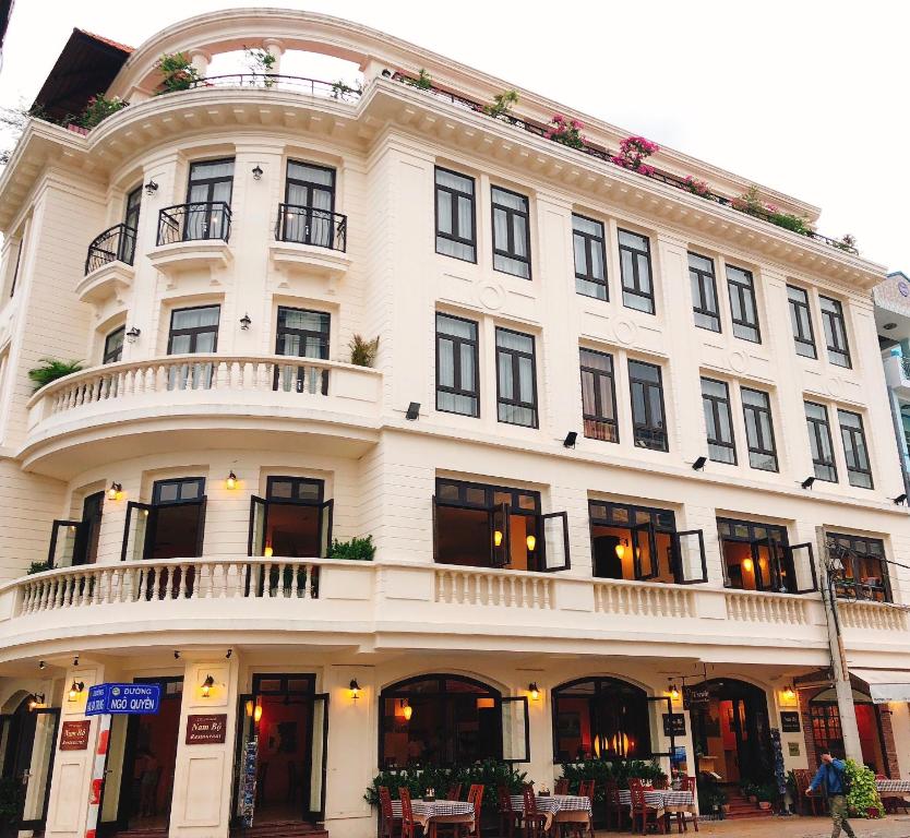 芹苴南波精品酒店的街道上一座大型白色建筑,设有阳台
