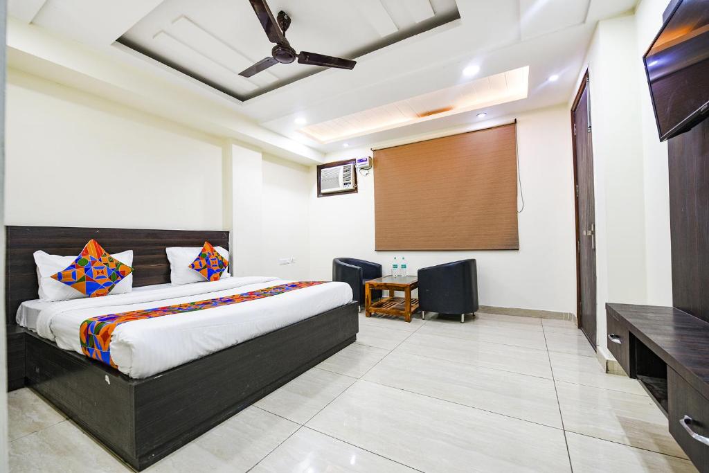 新德里FabHotel Dwarka Residency的一间卧室配有床和投影屏幕