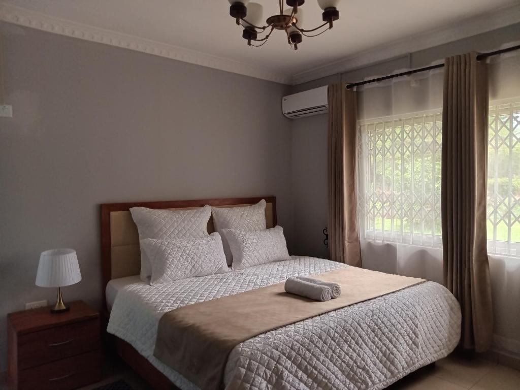 卢萨卡Nangoma Safari Lodge Lusaka的一间卧室配有一张带枕头的床