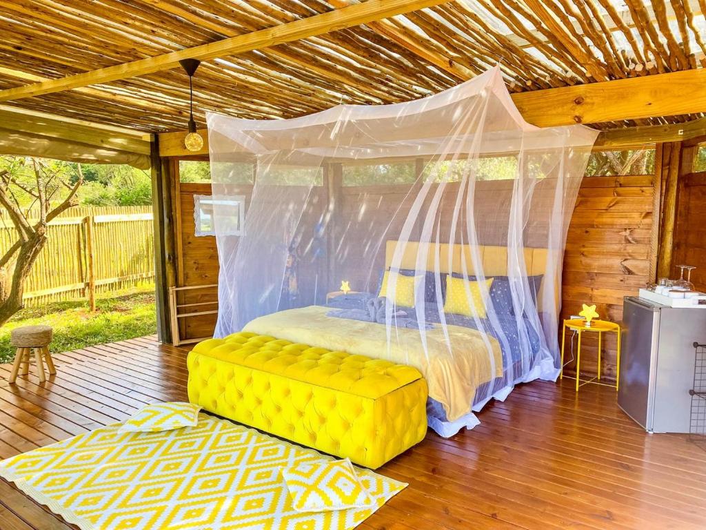 赫卢赫卢韦Hluhluwe Bush Camp Glamping Village的一间卧室配有一张带天蓬的床