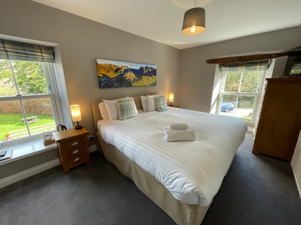 多克雷皇家酒店的卧室配有一张白色大床和两个窗户